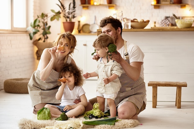 Foto famiglia felice con i loro figli che cucinano in cucina