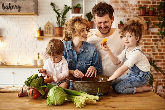 Счастливая семья с детьми готовит на кухне