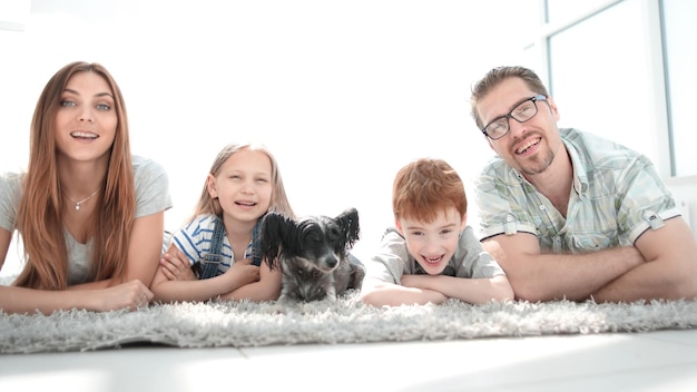 Happy family with two children lying in the new living roomphoto with copy space