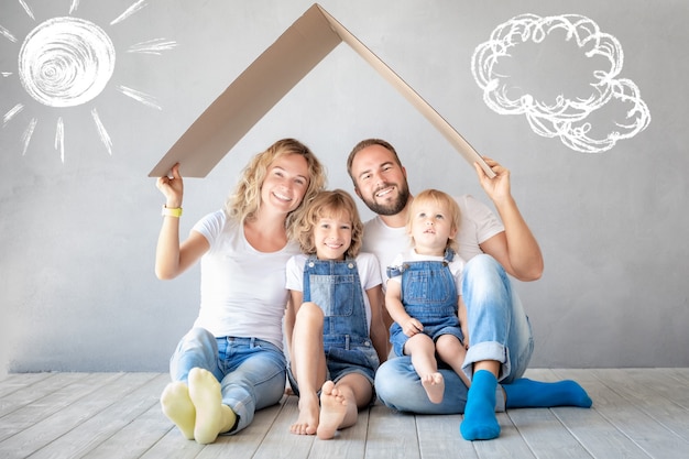 Famiglia felice con due bambini che giocano nella nuova casa