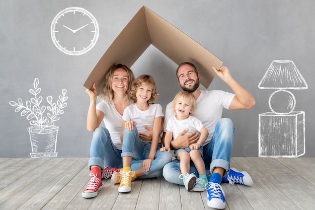 Happy family with two kids playing into new home