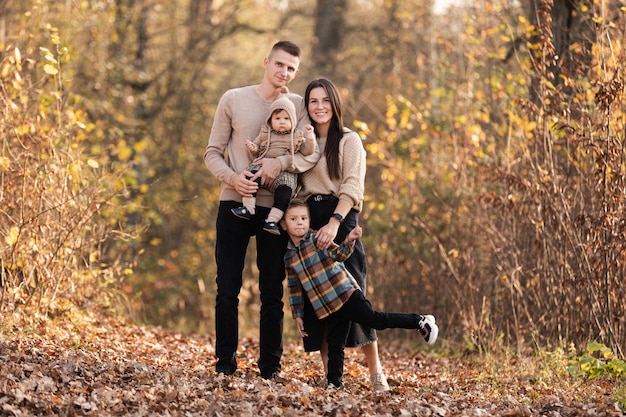 Happy family with two little children relaxing in the park