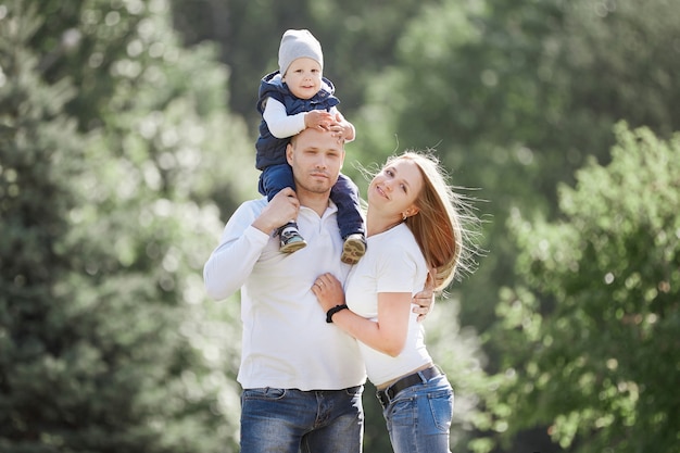 Happy family with a young son in the background of a summer Park.