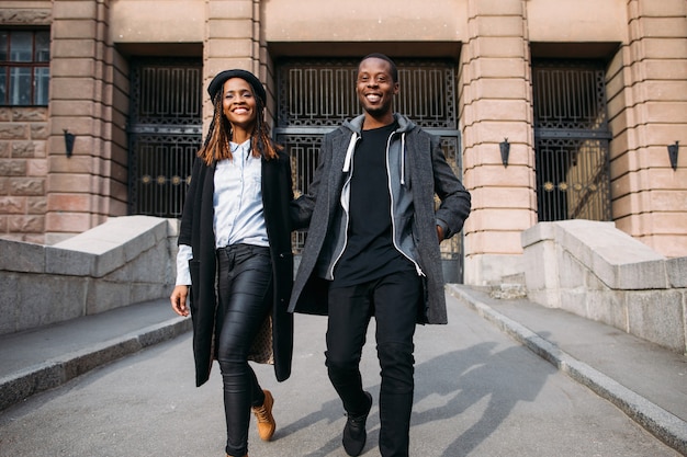 Happy fashionable pedestrians on city street. Smiling black people, African American joyful mood, happiness concept