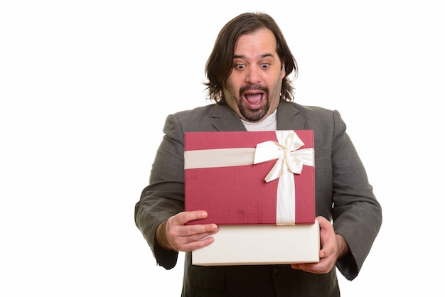 Счастливый толстый кавказский бизнесмен улыбается открытия подарочной коробки, изолированной на белом
