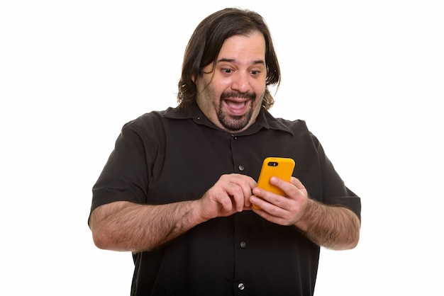 Счастливый толстый кавказский мужчина смеется при использовании мобильного телефона, изолированного на белом
