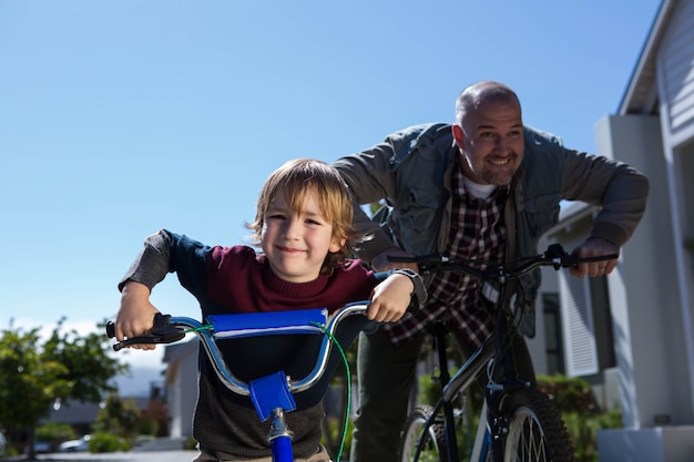 Happy father on a bike with his son on a sunny day