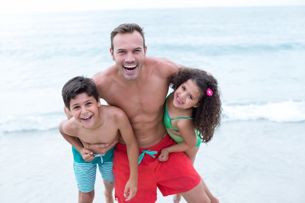 Happy father carrying children while standing