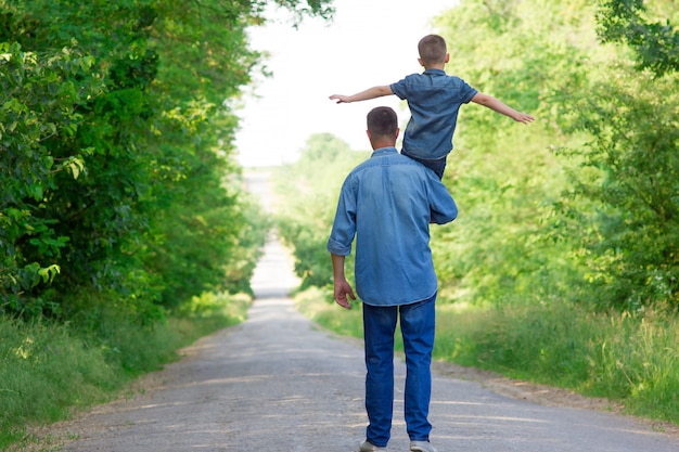 Happy father and child walk along the road concept