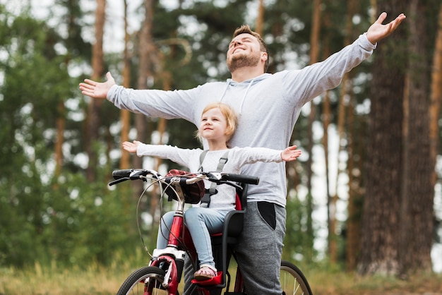 Photo happy father and daughter on bicycle