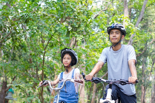 幸せな父と娘が公園でサイクリング