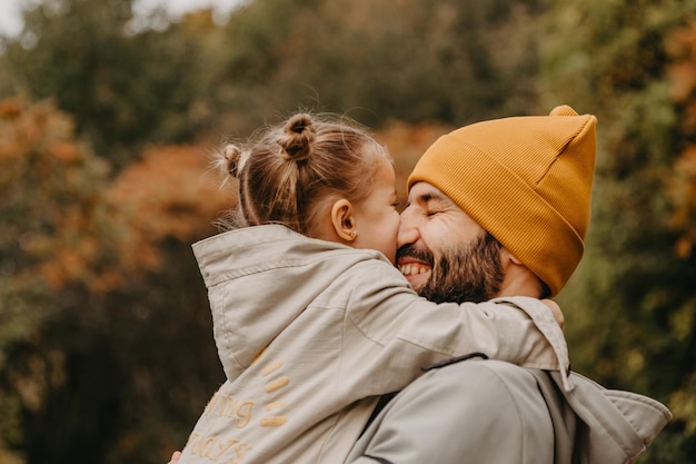 Happy father and daughter playing while walking in a beautiful autumn park Ideal weekend father with his little daughter autumnal mood