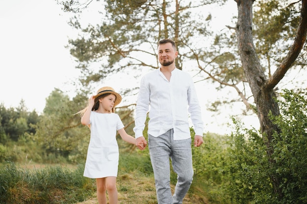 Happy father and daughter playing while walking in a beautiful summer park Ideal weekend father with his little daughter