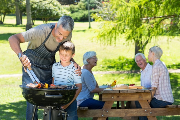 Happy father doing barbecue with his son 