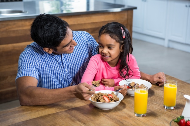 Happy father having breakfast with his daughter