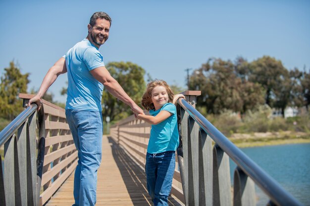 Happy father having fun with his son walking outdoor, summer.