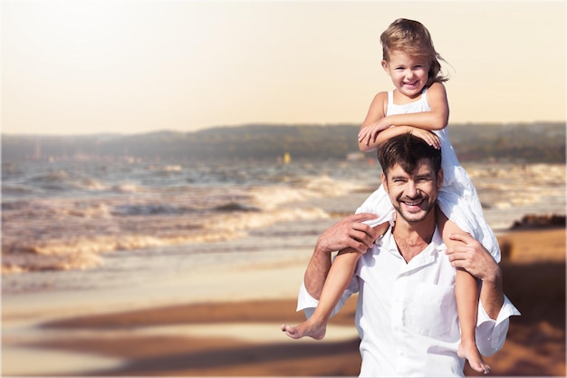 Счастливый отец и его милая маленькая дочь на пляже