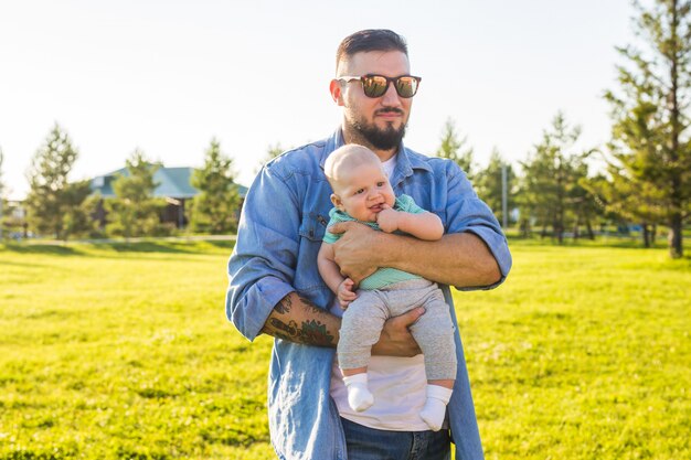 Happy father holding baby son. Concept of happy family, father's day and child.