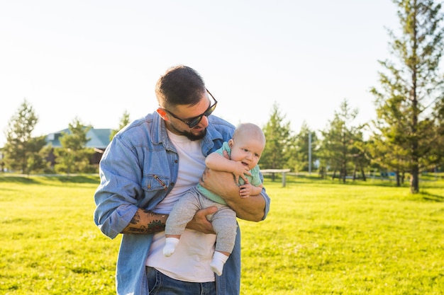 Foto padre felice che tiene in braccio il concetto di figlio bambino di felice festa del papà e bambino in famiglia