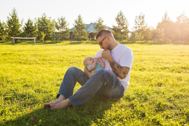 幸せな家族の父の日と子の自然の概念に赤ちゃんの息子を保持している幸せな父