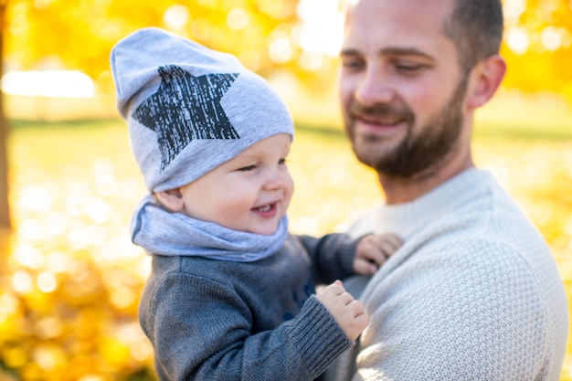 Happy father holding his little child outdoor.