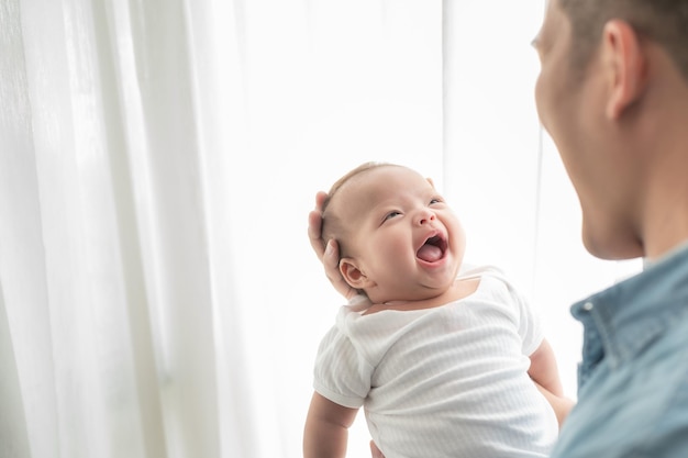 Happy father holding his smiling adorable baby girl