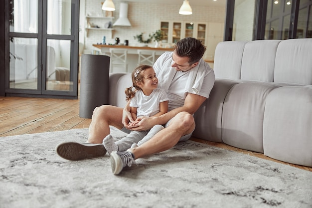 Happy father hugging his daughter in cozy apartment