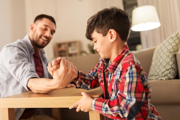 Foto padre felice e figlio piccolo braccio a braccio a casa