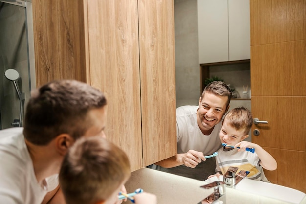 Photo a happy father and little son having morning routine in a bathroom