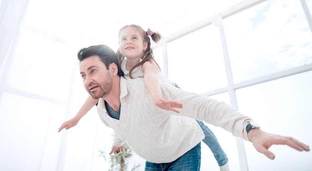 Happy father playing with his daughter at home