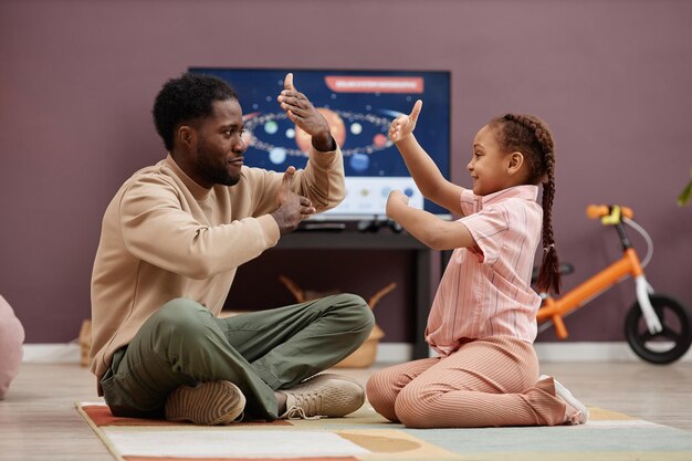 Photo happy father playing with little girl and dancing at home