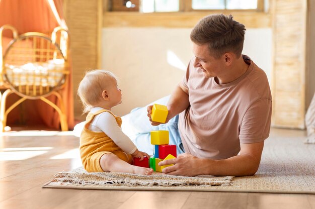 Happy father playing with little infant baby son or daughter at home