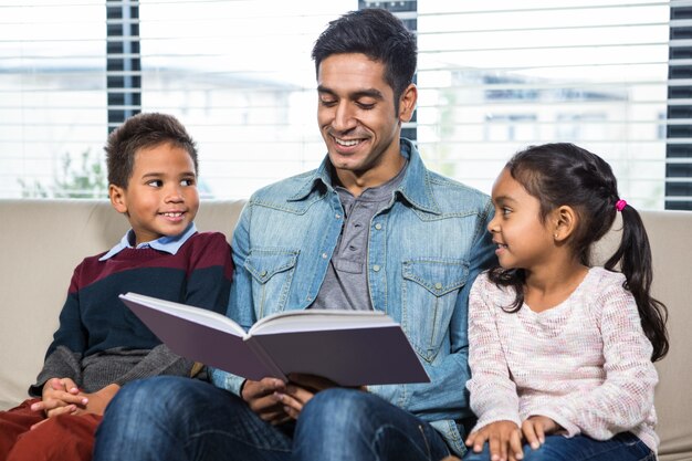 彼の子供のための本を読む幸せな父