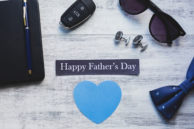 Happy Father's Day achtergrond. Manchetknoop, autosleutel, vlinderdas, pen en zonnebril.