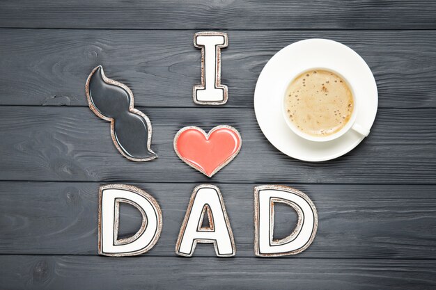 Happy father's day concept. Cup of coffee and cookies. Text i love dad