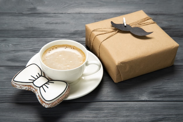 Foto felice festa del papà concetto. biscotti e tazza di caffè saporiti su fondo di legno