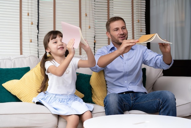 Happy Father's day Funny portrait of smiling father and her daughter sitting sofa