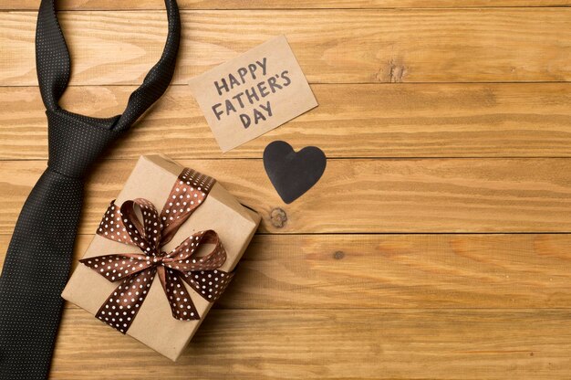 Happy Father's Day inscription with different gifts on wooden background top view