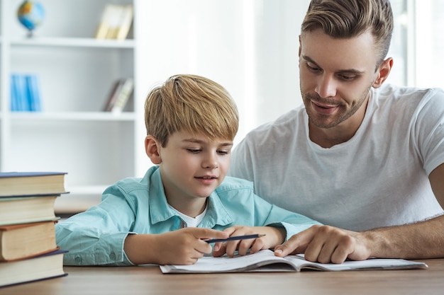 The happy father and a son doing homework at the desk