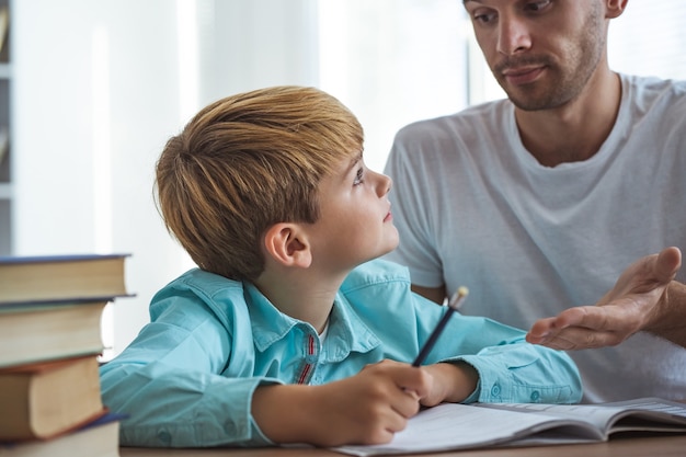 The happy father and a son doing homework at the desk