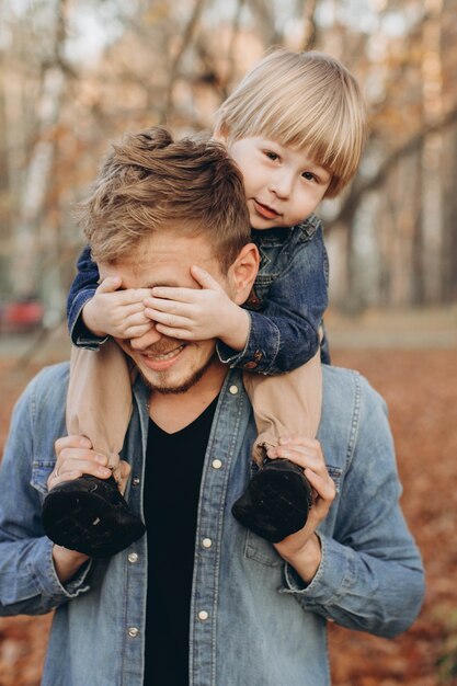 Happy father and son having fun in autumn park