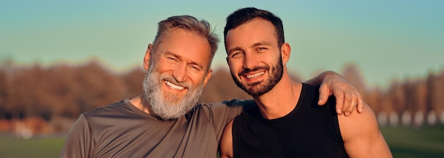 Foto il padre e il figlio felici si abbracciano all'aperto