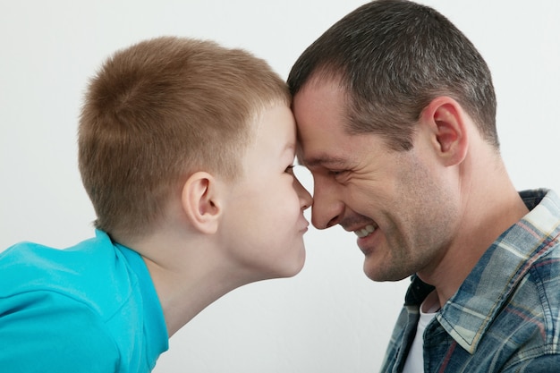 Padre e figlio felici che giocano e che ridono insieme a casa.