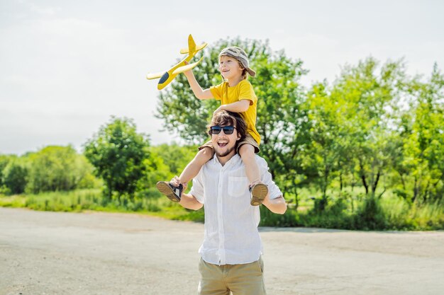 Happy father and son playing with toy airplane against old runway background Traveling with kids concept