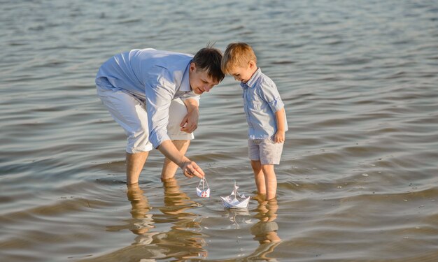 Счастливый отец и сын запускают корабль на воде