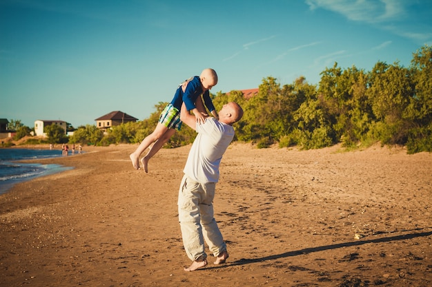 幸せな父と息子、ビーチの上を歩いて