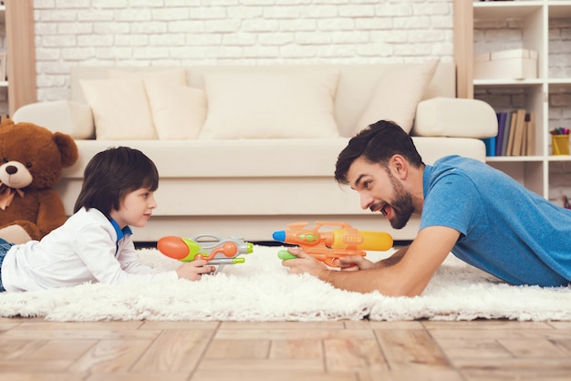 Happy father and sons sta giocando con toys gun.