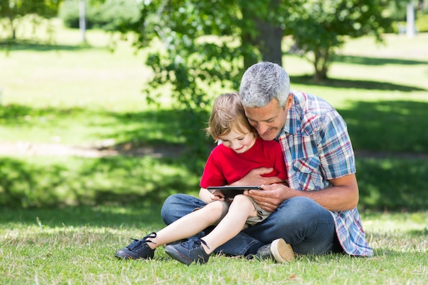 Happy father using tablet pc with his son 