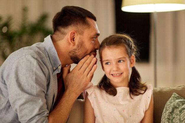 Photo happy father whispering secret to daughter at home