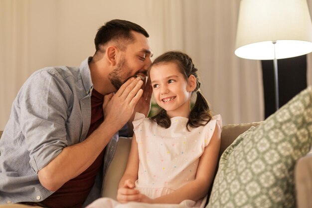 Photo happy father whispering secret to daughter at home